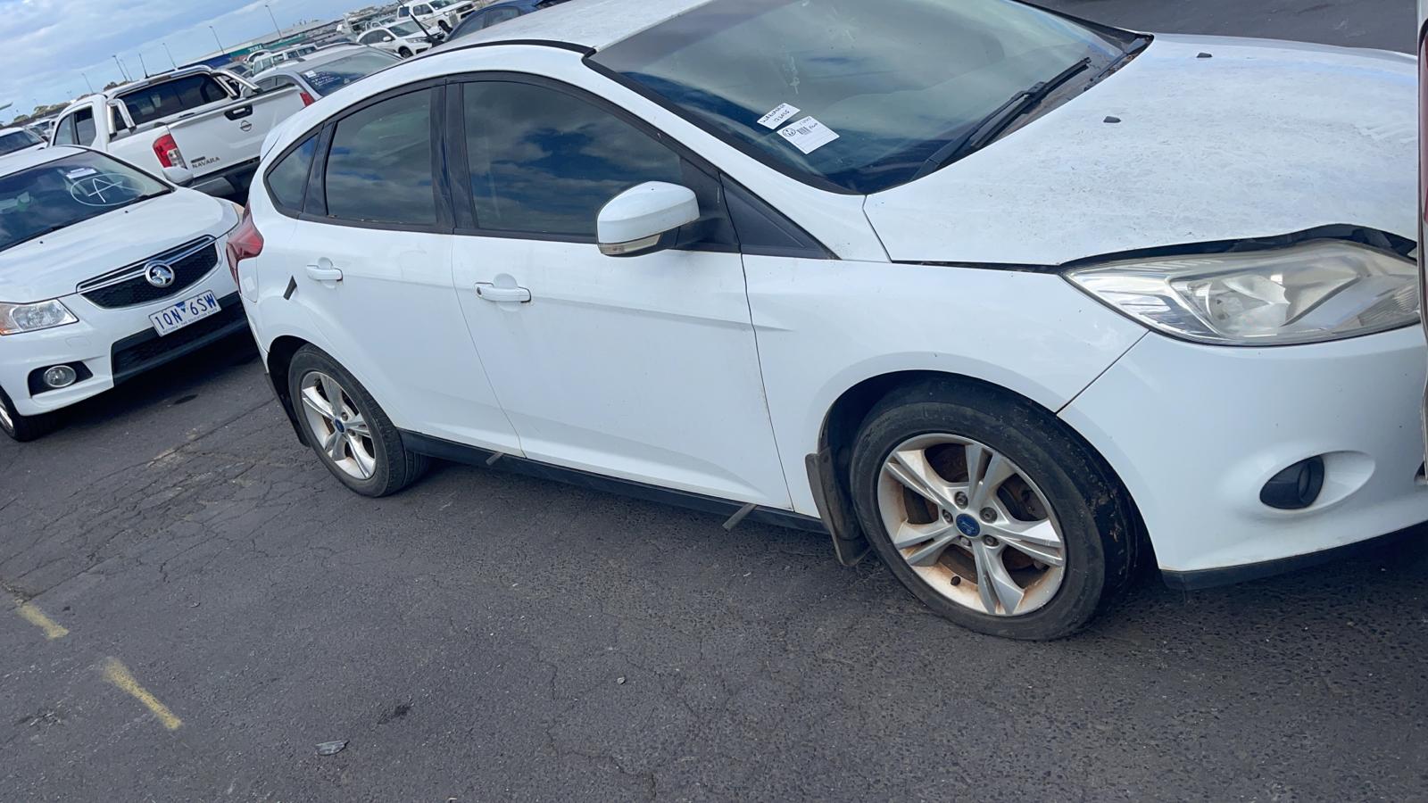 White hatchback in a vehicle yard