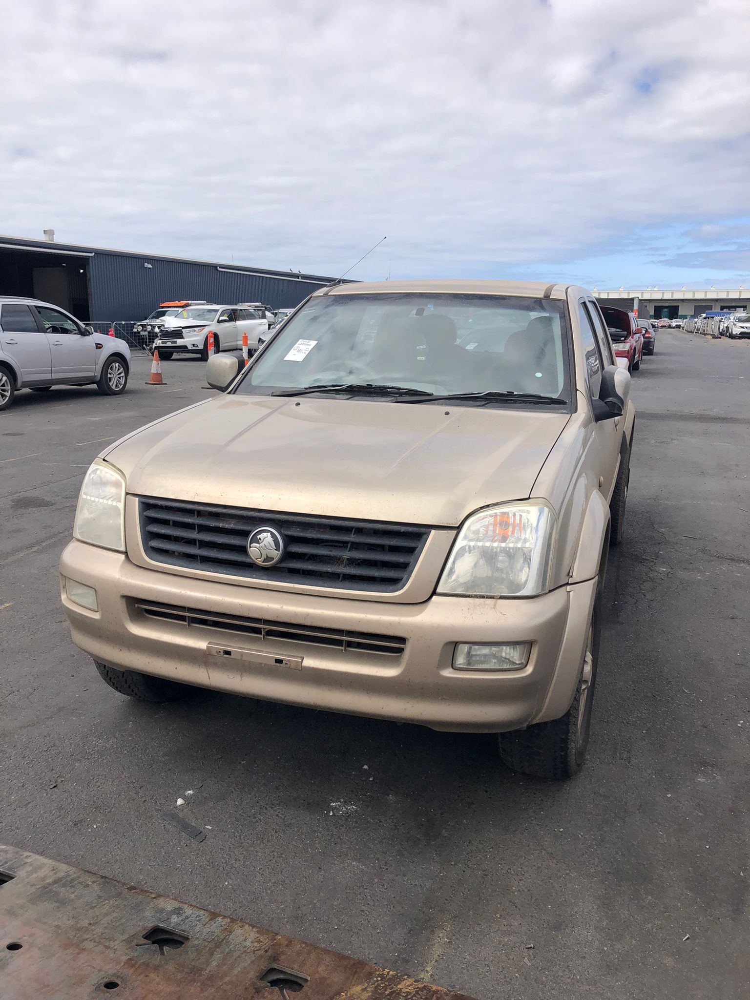 Beige utility vehicle in a vehicle yard