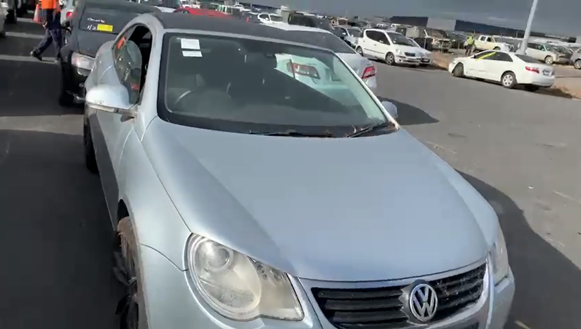 Silver convertible in a vehicle yard